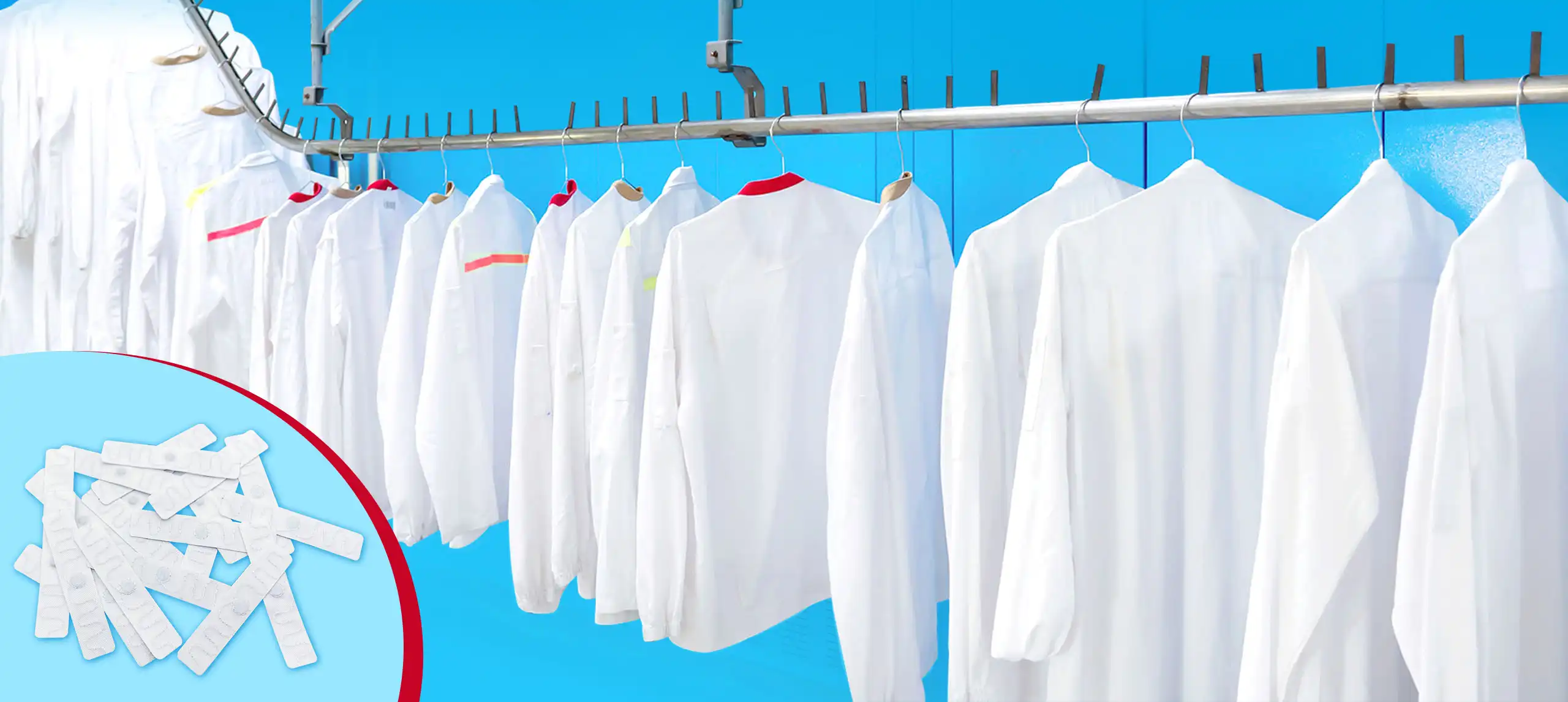 White uniforms on an industrial laundry conveyor rail with textile RFID laundry tags