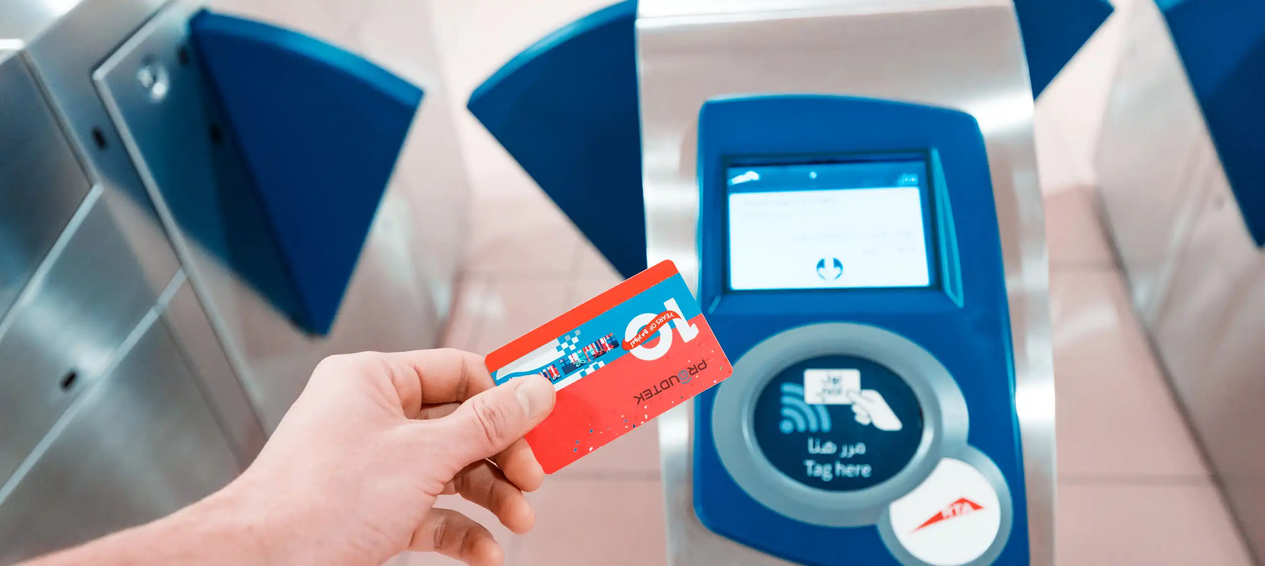 Hand tapping a printed RFID smart card on a metro fare gate reader — contactless transit ticketing