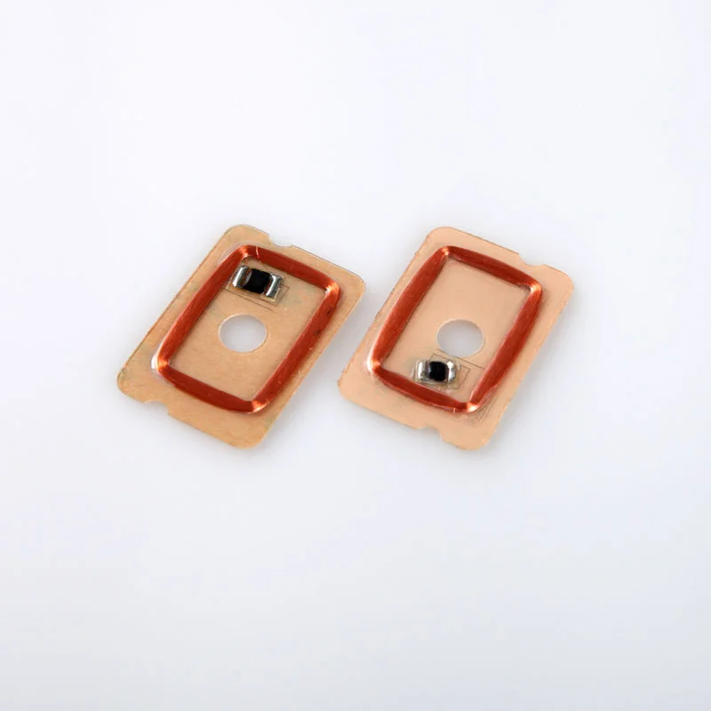 Two amber rectangular component examples with copper coils, chip areas and central holes.